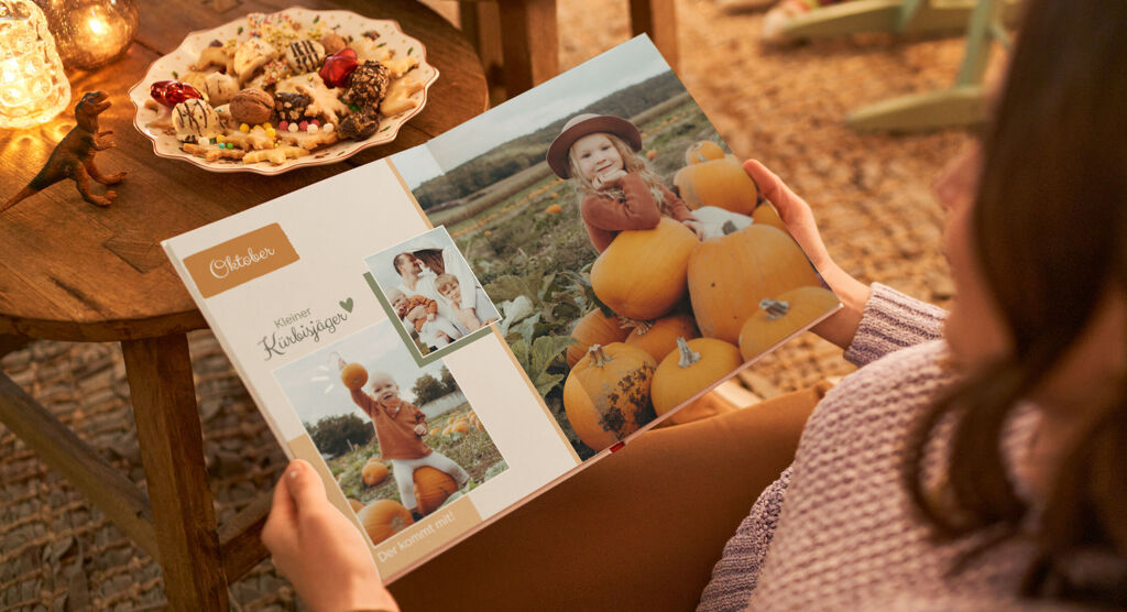 Auf der CEWE FOTOBUCH Doppelseite sind links zwei Bilder der Familie in einem Kürbisfeld und abgehoben ein Text "Oktober". Rechts ist vollflächig das Bild eines Mädchens im Kürbisfeld gezogen.